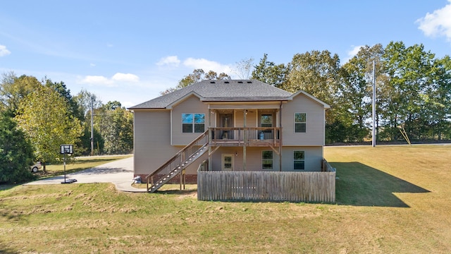 rear view of property featuring a deck and a yard