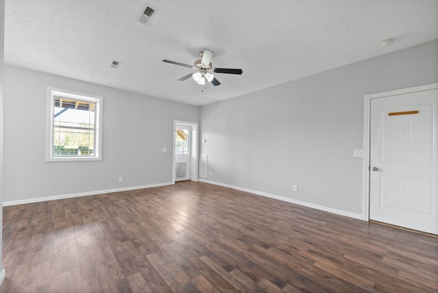 empty room with dark wood-type flooring, a textured ceiling, and ceiling fan