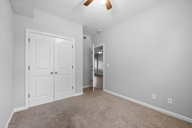 unfurnished bedroom featuring a closet, ceiling fan, and carpet floors