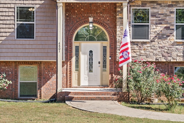 view of exterior entry with a lawn