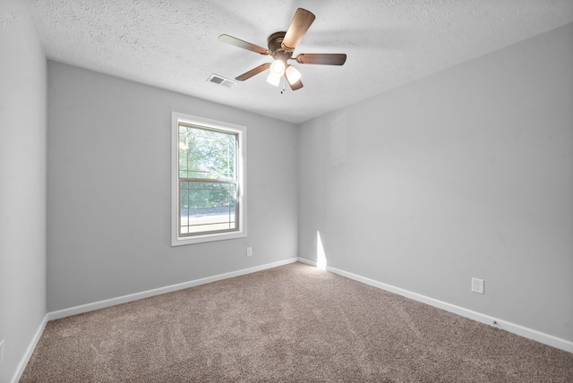 spare room featuring a textured ceiling, carpet floors, and ceiling fan