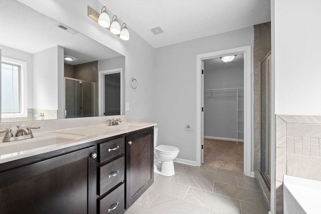 bathroom with a shower with door, vanity, and toilet