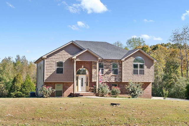 raised ranch featuring cooling unit and a front yard