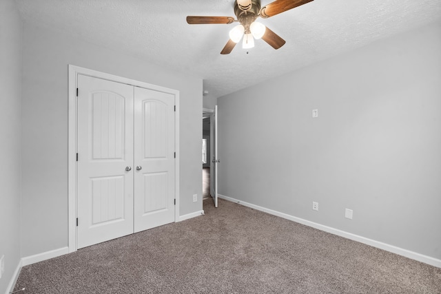 unfurnished bedroom with a textured ceiling, carpet flooring, a closet, and ceiling fan