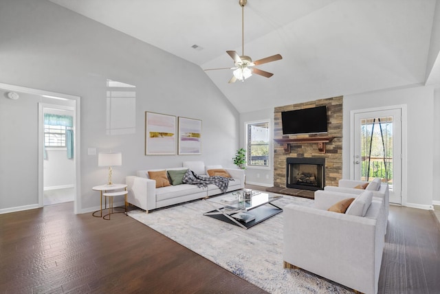 living area featuring dark wood-style floors, a fireplace, and a wealth of natural light