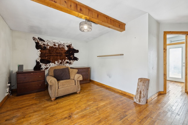 living area featuring lofted ceiling with beams and wood-type flooring