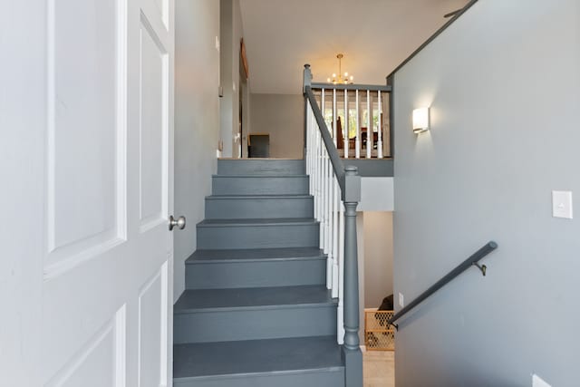 stairway featuring a notable chandelier and tile patterned floors