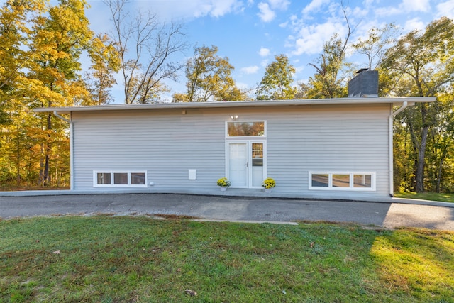 back of house with a patio area and a lawn