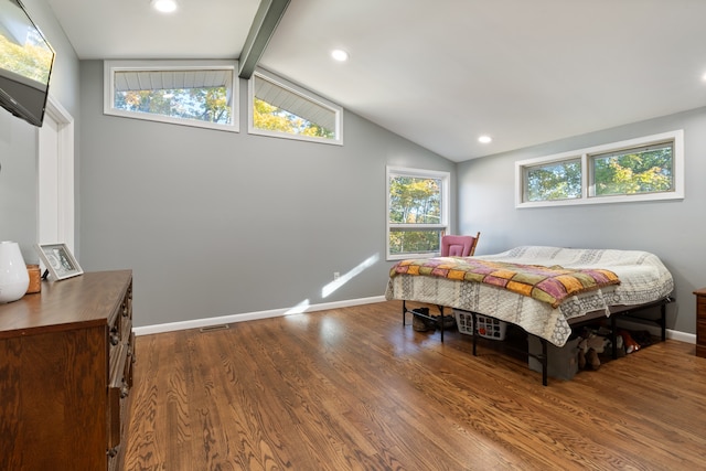 bedroom featuring hardwood / wood-style floors and vaulted ceiling with beams