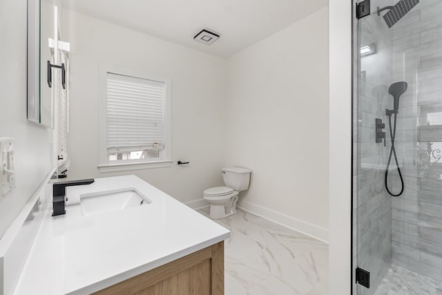 bathroom featuring toilet, vanity, and a shower with door