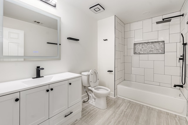 full bathroom featuring vanity, tiled shower / bath combo, and toilet