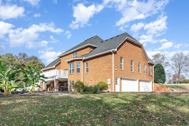 view of side of home with a garage, a lawn, and a balcony