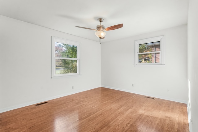 spare room with ceiling fan, plenty of natural light, and hardwood / wood-style floors