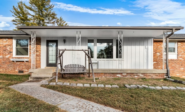 ranch-style house featuring covered porch and a front lawn