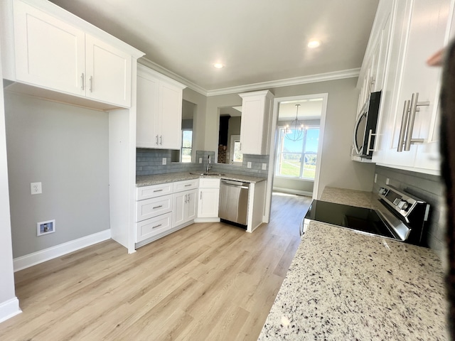 kitchen with sink, white cabinetry, light hardwood / wood-style flooring, ornamental molding, and stainless steel appliances