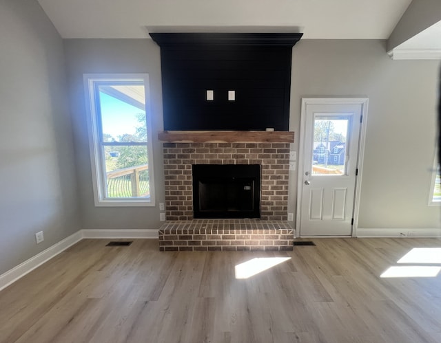 unfurnished living room with plenty of natural light, light hardwood / wood-style flooring, and a fireplace