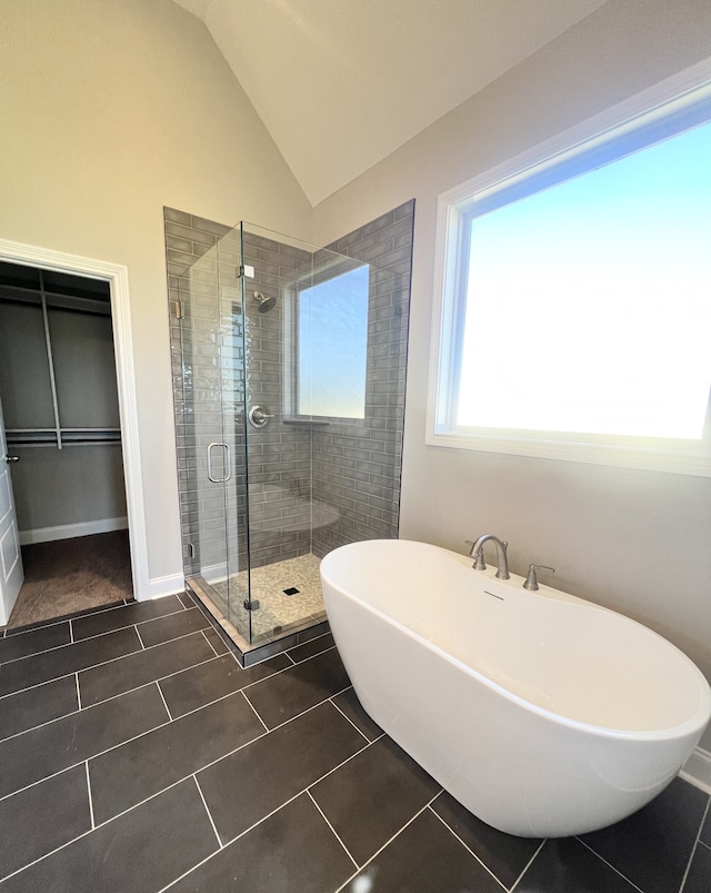 bathroom featuring vaulted ceiling, shower with separate bathtub, and tile patterned floors