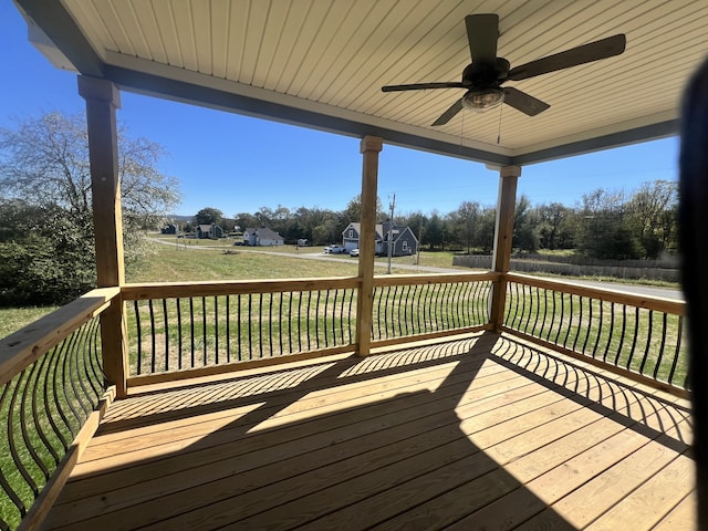 wooden terrace featuring ceiling fan and a yard