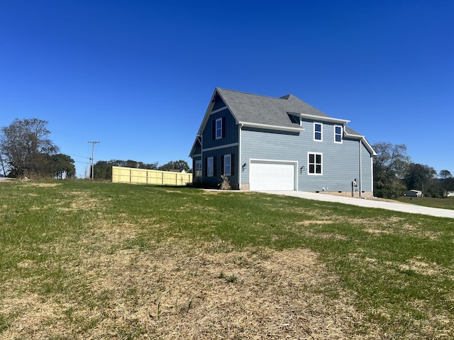 view of side of home with a garage and a lawn