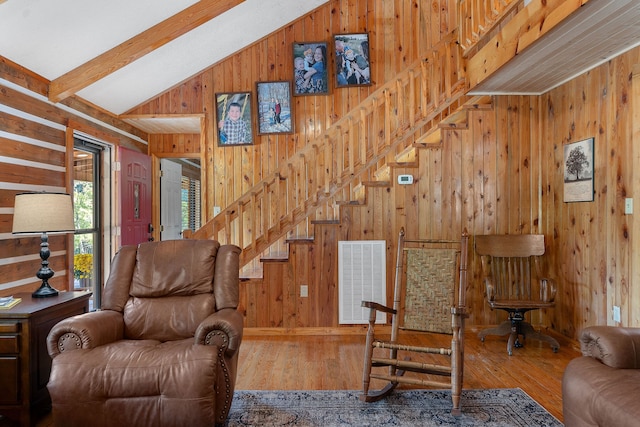 living room with hardwood / wood-style floors, vaulted ceiling with beams, and wood walls