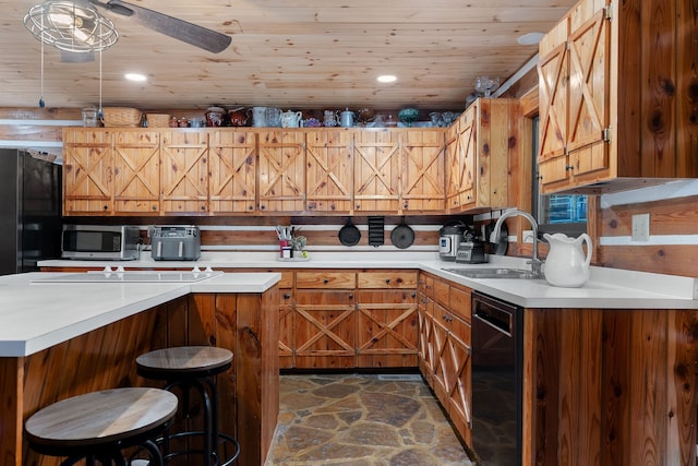 kitchen with wooden ceiling, sink, black appliances, a breakfast bar, and ceiling fan