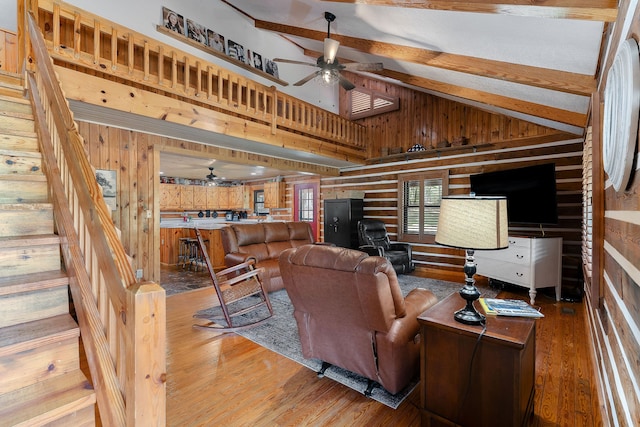 living room featuring vaulted ceiling with beams, hardwood / wood-style flooring, and wood walls