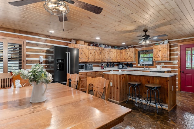 dining space featuring ceiling fan, sink, and wood ceiling