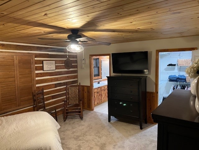 carpeted bedroom featuring connected bathroom, wooden walls, wood ceiling, and ceiling fan