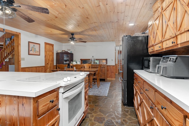 kitchen featuring appliances with stainless steel finishes, wood ceiling, wood walls, and ceiling fan