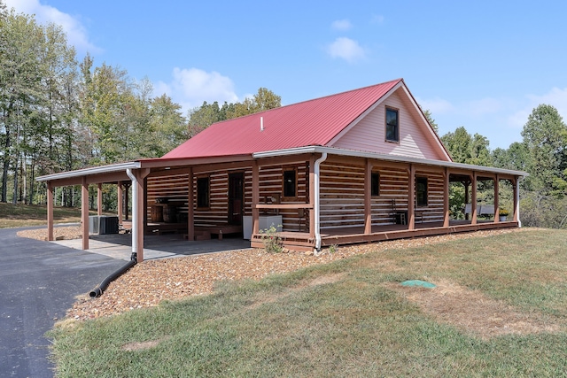 view of front of house with a front yard, cooling unit, and a carport