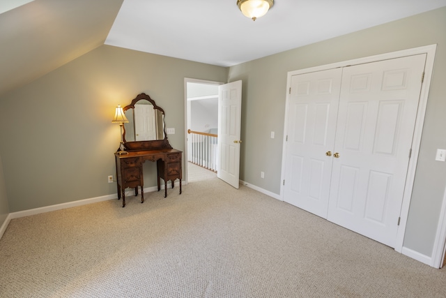 carpeted bedroom with a closet and lofted ceiling