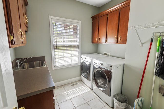 laundry area with cabinets, light tile patterned flooring, sink, and washer and clothes dryer