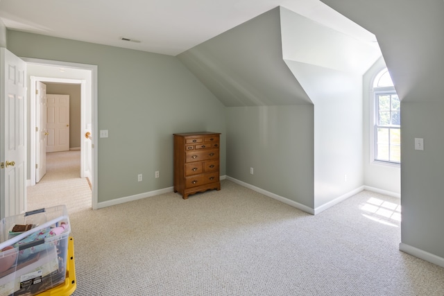 bonus room featuring vaulted ceiling and light colored carpet