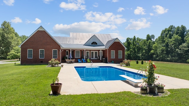 view of swimming pool with a yard, a patio, and a diving board