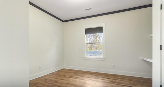 unfurnished room featuring ornamental molding and hardwood / wood-style flooring