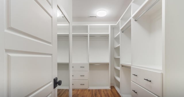 walk in closet with dark hardwood / wood-style flooring