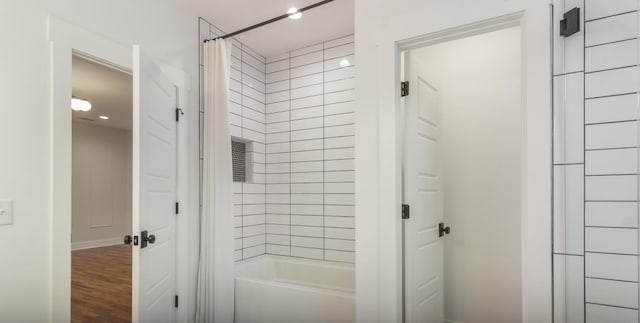 bathroom with wood-type flooring and shower / tub combo