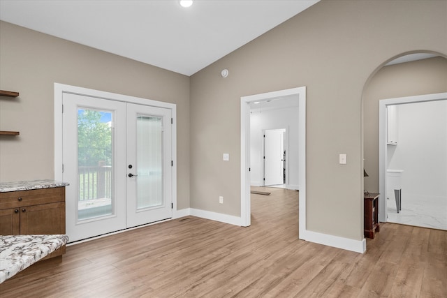 foyer entrance featuring french doors, light hardwood / wood-style floors, and lofted ceiling