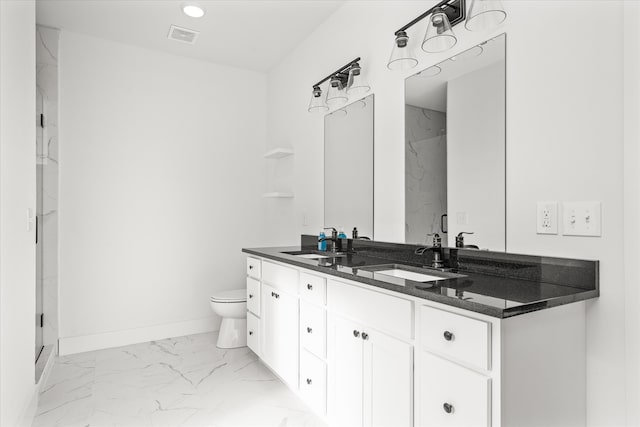 bathroom with vanity, a shower with shower door, and toilet