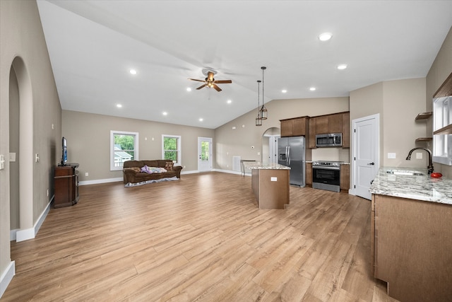 kitchen featuring sink, hanging light fixtures, light hardwood / wood-style floors, stainless steel appliances, and lofted ceiling