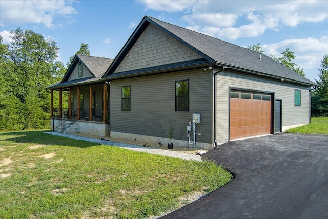 view of property exterior with roof with shingles, covered porch, a yard, a garage, and driveway