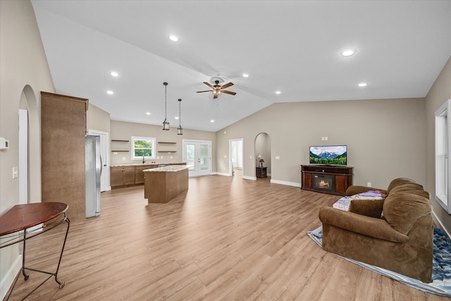 living room with lofted ceiling, light wood-type flooring, and ceiling fan