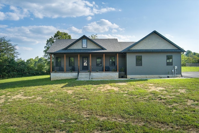 rear view of house with a porch and a yard