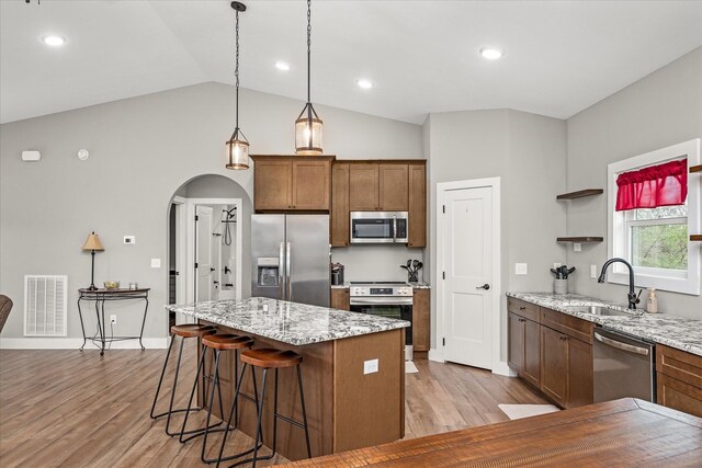 kitchen with visible vents, a sink, a center island, stainless steel appliances, and open shelves