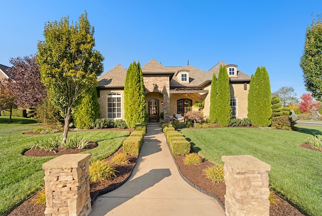 french provincial home with a front yard