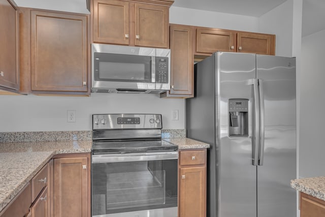 kitchen featuring light stone counters and stainless steel appliances