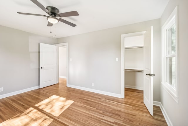 unfurnished bedroom featuring light hardwood / wood-style flooring, multiple windows, a closet, and ceiling fan