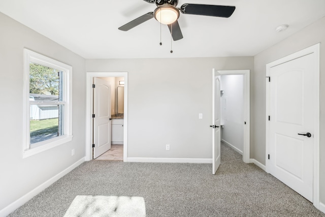 unfurnished bedroom featuring connected bathroom, ceiling fan, and light colored carpet