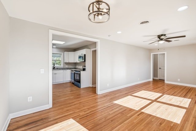 unfurnished living room with light wood-type flooring and ceiling fan