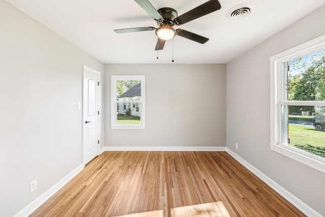 spare room with a wealth of natural light, light wood-type flooring, and ceiling fan